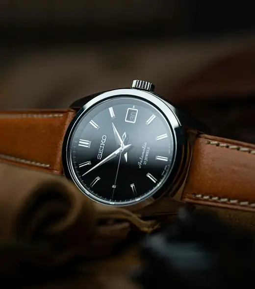 Steel watch with a tan leather strap