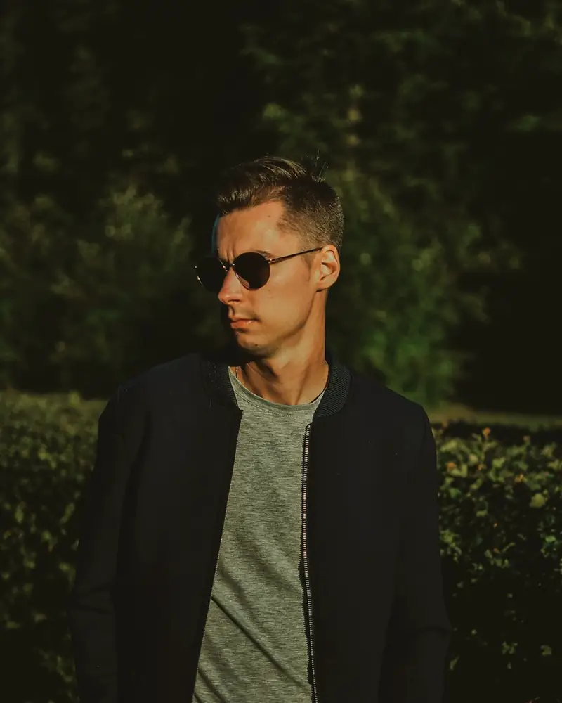 Man in a navy bomber jacket and sunglasses
